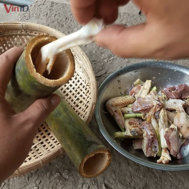 Placing marinated and cut chicken into the bamboo tube