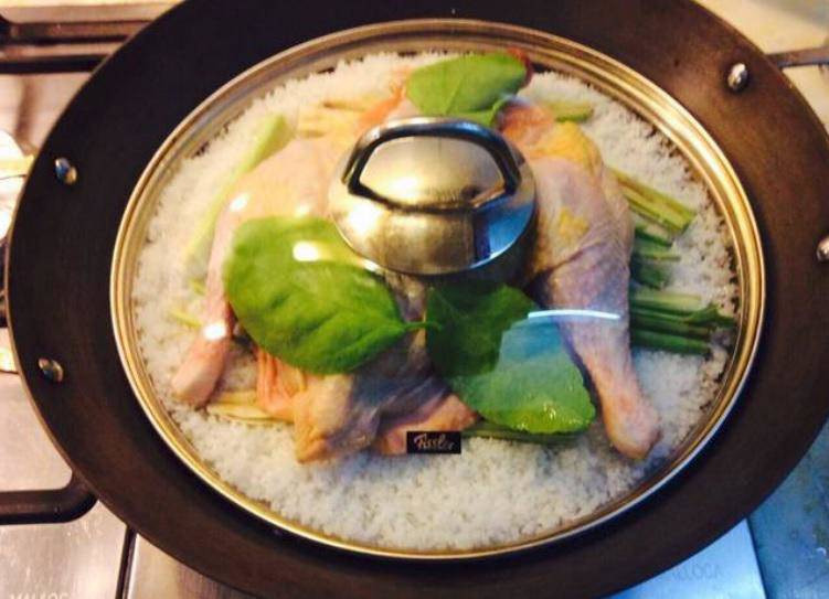 Steaming chicken on a bed of salt and lemongrass