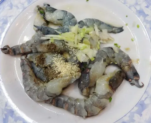 Marinating shrimp with seasonings to enhance flavor