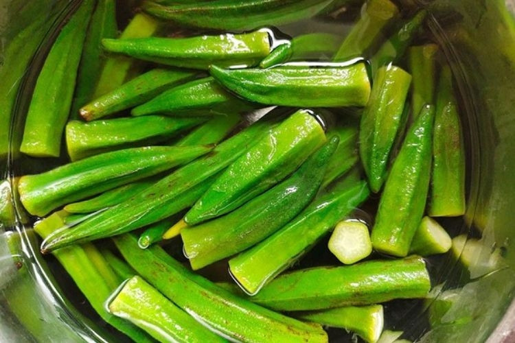 Soaking okra in lightly salted water to reduce sliminess
