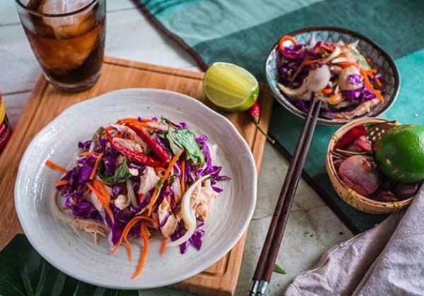 Adding roasted peanuts to the chicken and cabbage salad