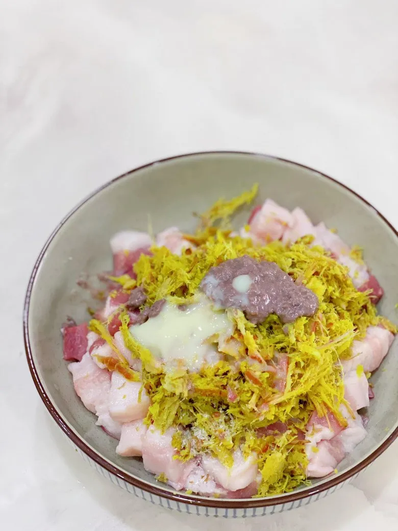 Marinar las costillas de cerdo con la mezcla de condimentos - Paso crucial en la receta de costillas de cerdo asadas con jengibre y mẻ