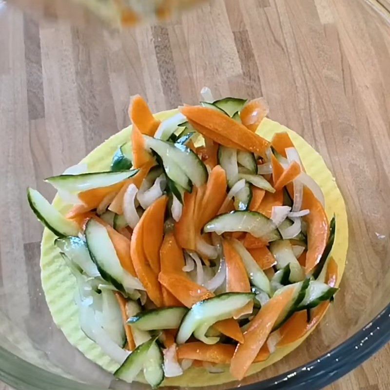 Tossing the snow fungus salad ingredients with dressing in a large bowl