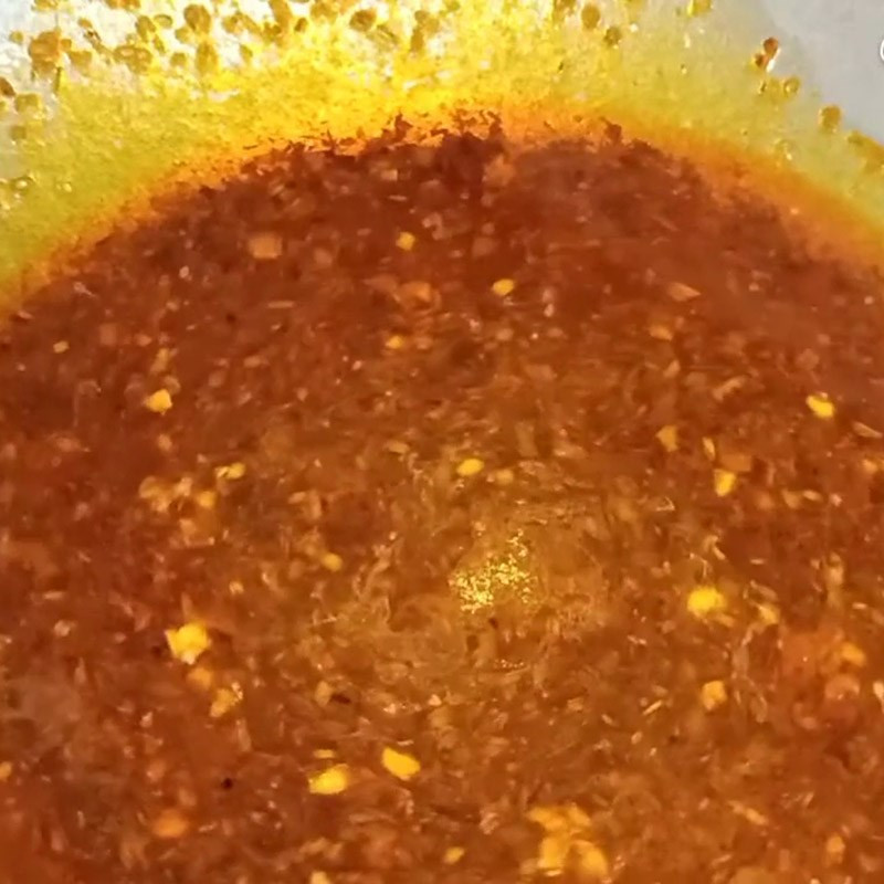 Salsa roja con hierba limón y ajo sofriéndose en una sartén