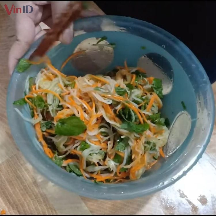 Mezclando la ensalada de chayote y tomate