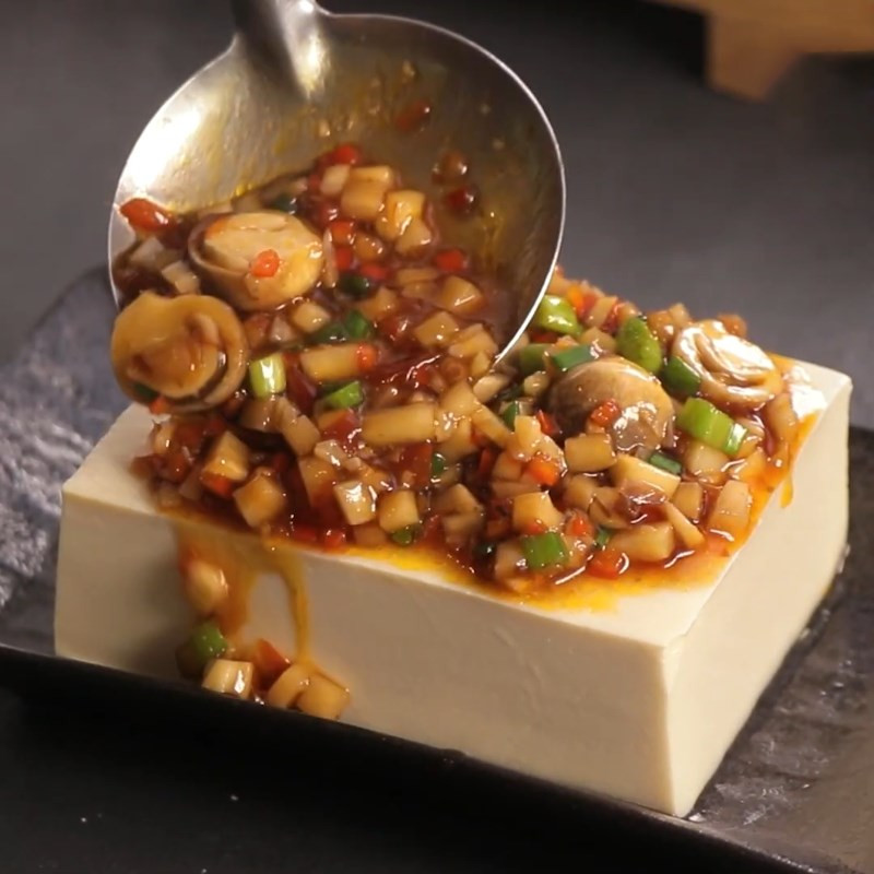 Braised silken tofu with mushroom sauce drizzled on top, ready to serve